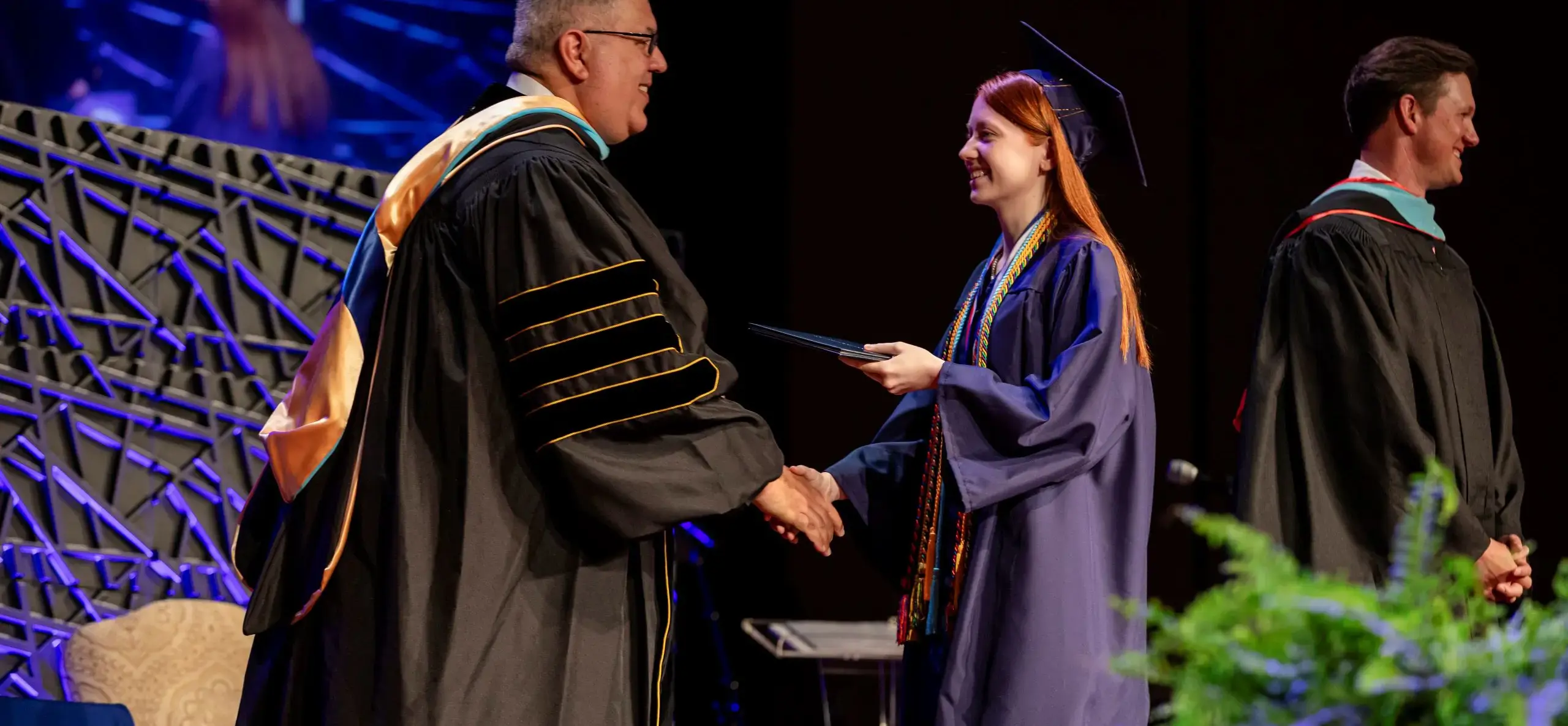 Student receives diploma at graduation ceremony