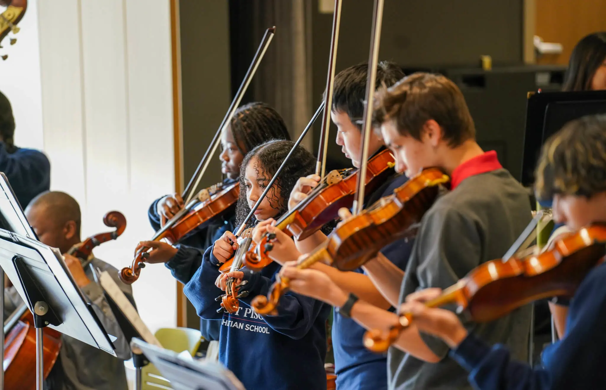 Row of students playing the violin