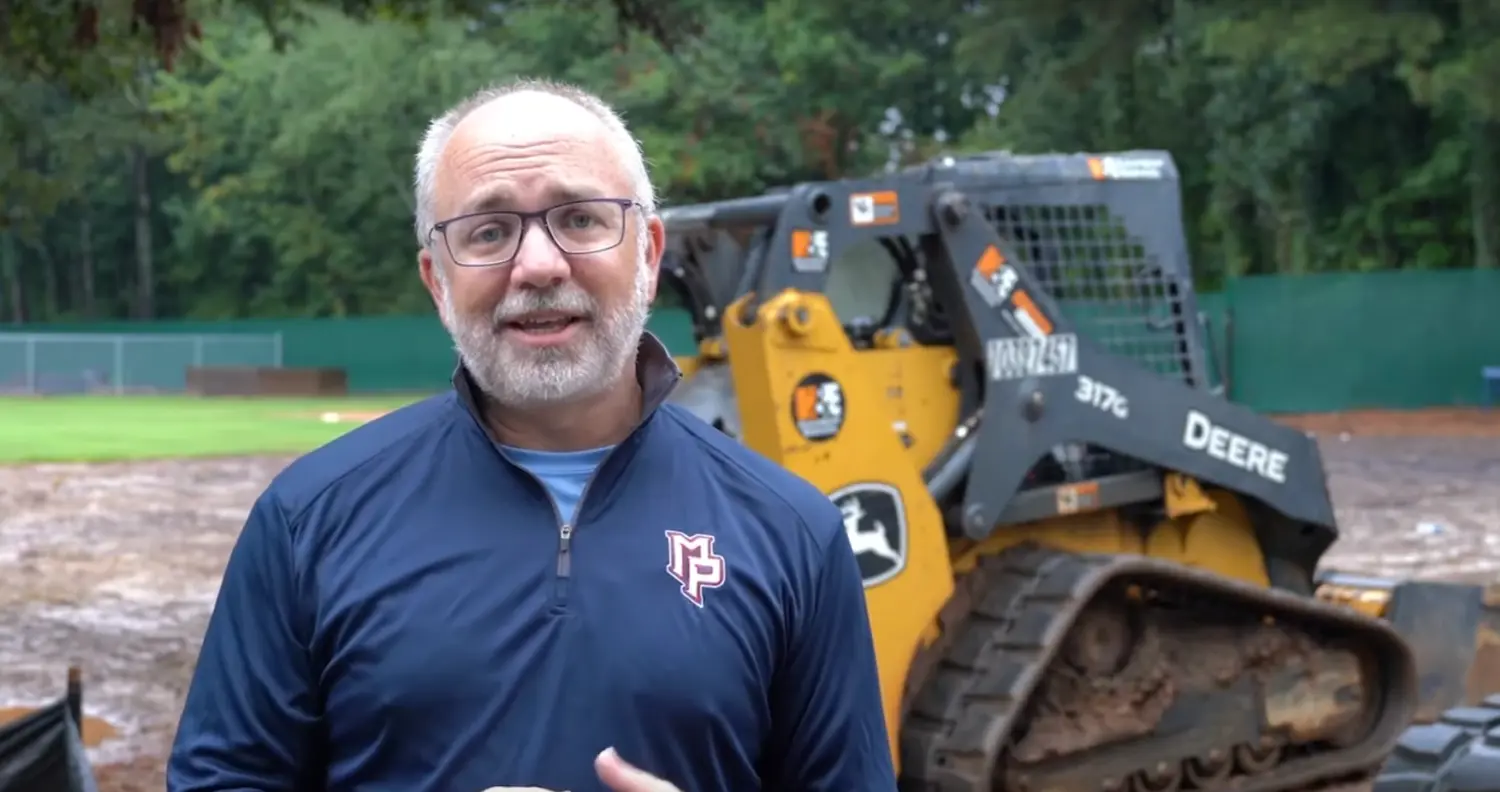 Man talking in front of heavy machinery