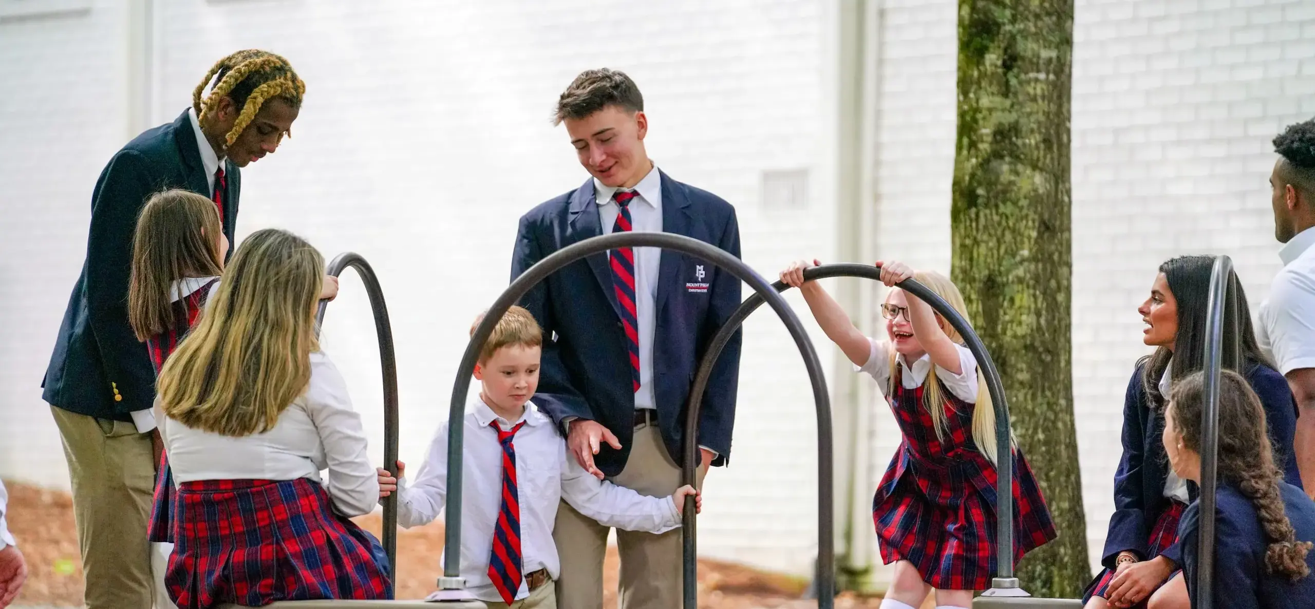 Upper school students supervising lower school students on playground