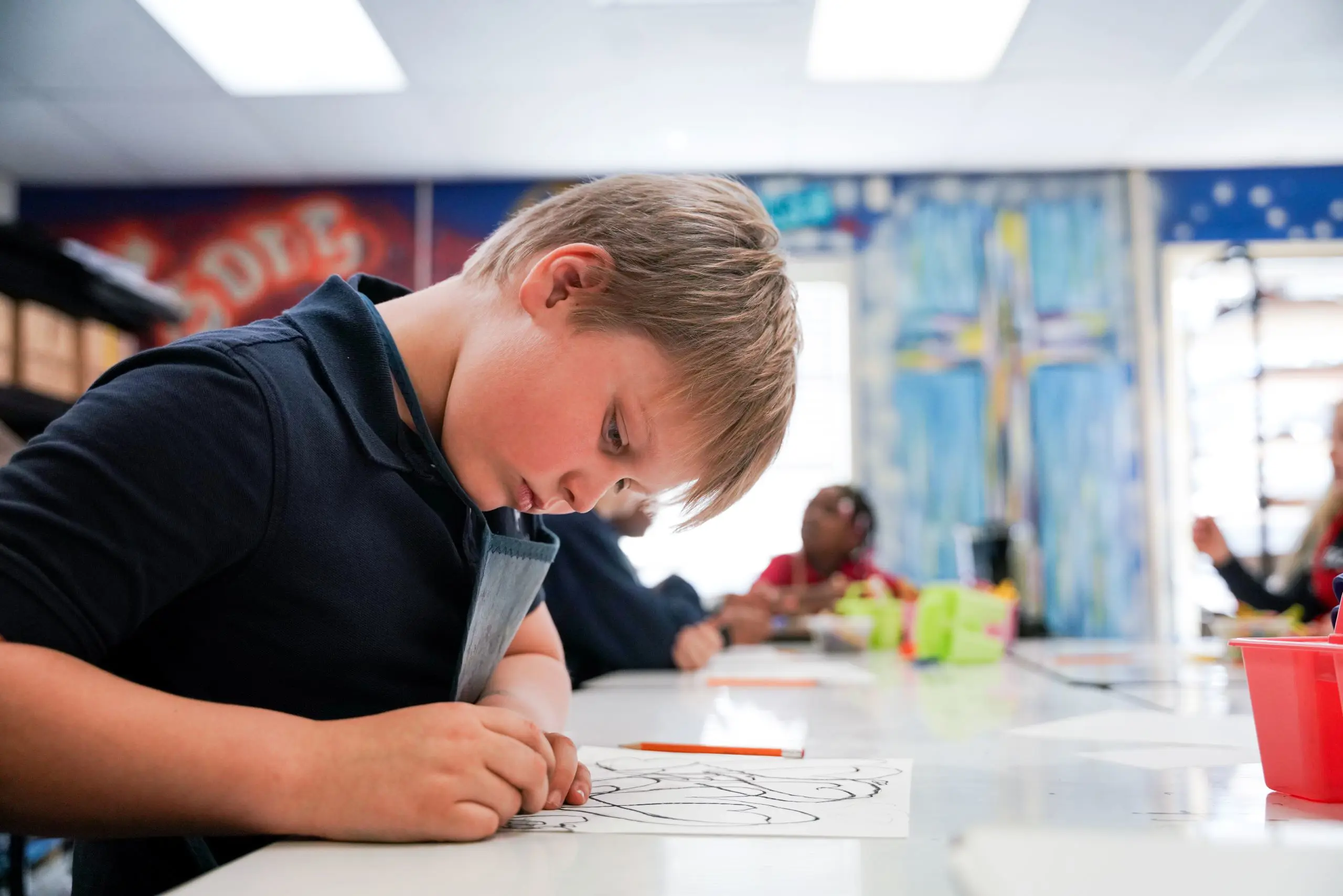 Young boy drawing on a piece of paper