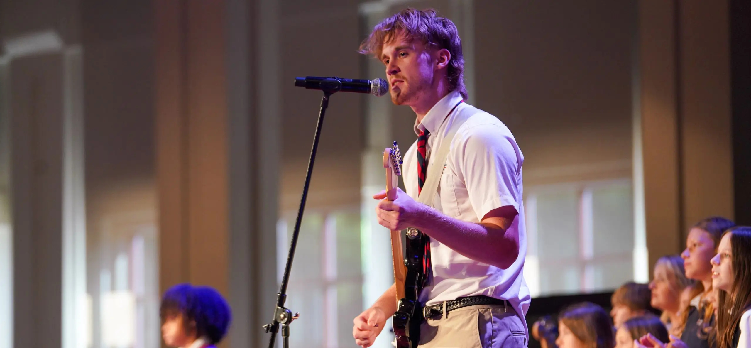 Man performing on stage with guitar